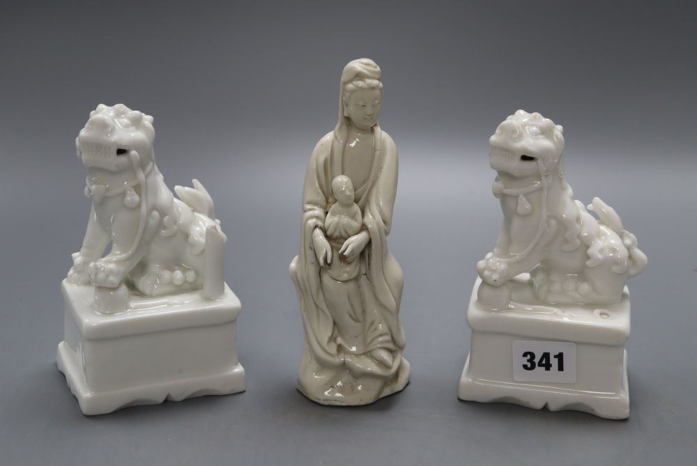 A pair of Chinese blanc de chine lion-dogs and a similar group of Guanyin, height 17cm